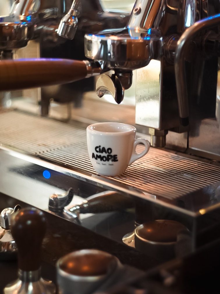 Une tasse d'espresso est posée sur une machine à café à porte-filtre