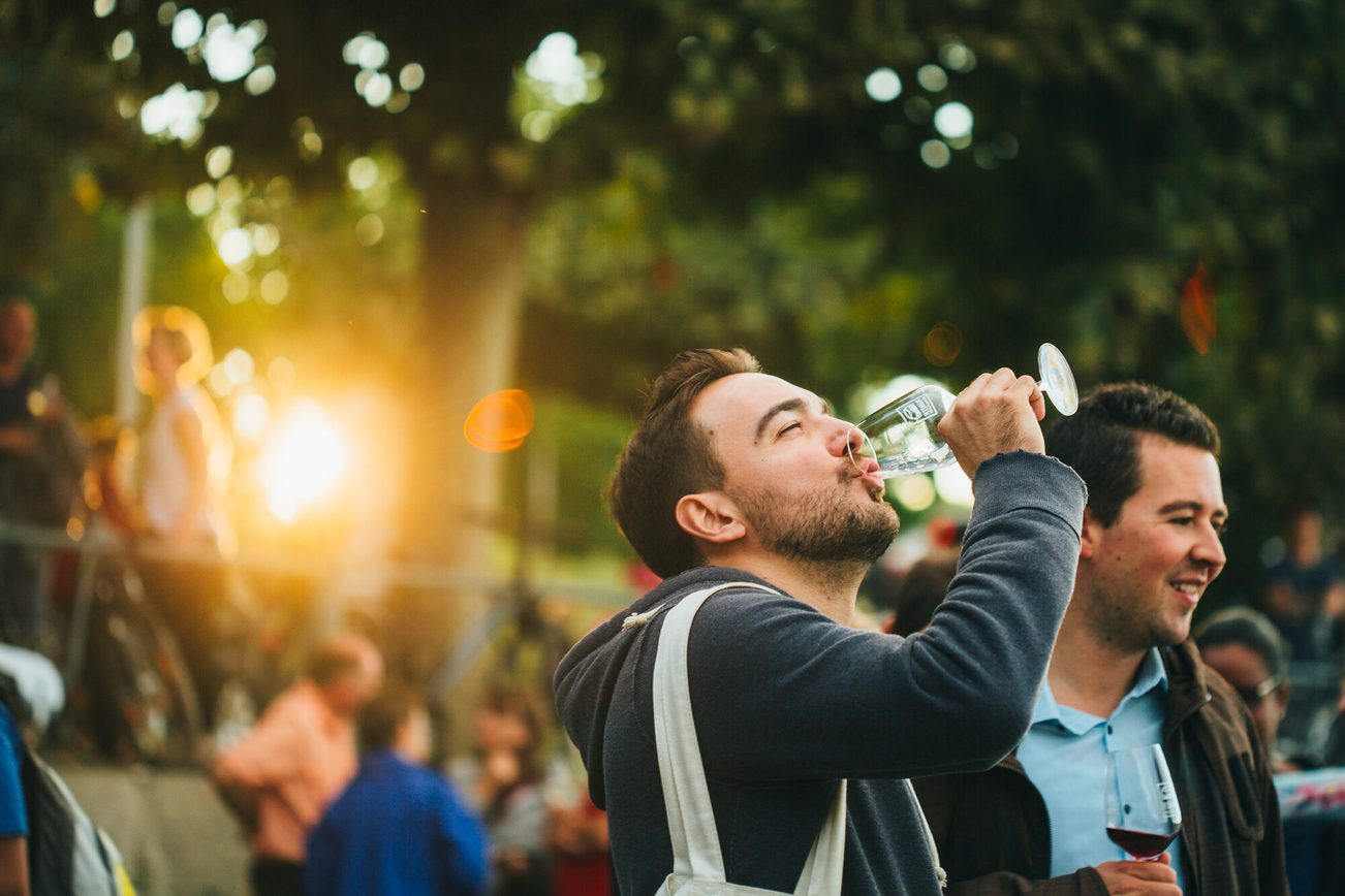 Jeune visiteur au Salon du vin, un verre de vin à la main