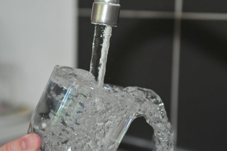 Il vetro viene riempito sotto un rubinetto