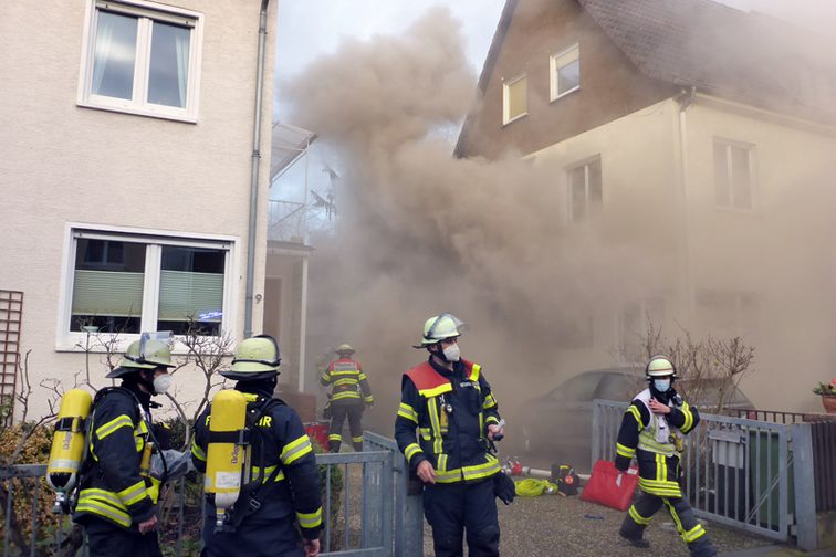 Rettungskräfte an der Einsatzstelle. Aufsteigender Rauch im Hintergrund.
