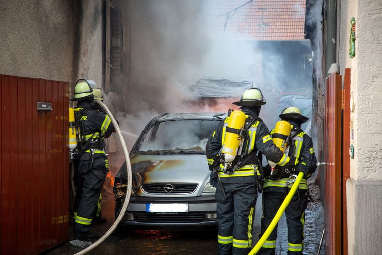 Einsatzkräfte löschen den Brand im Hinterhof.