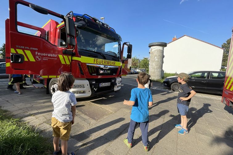 Los niños inspeccionan los vehículos de emergencia en el lugar de los hechos.