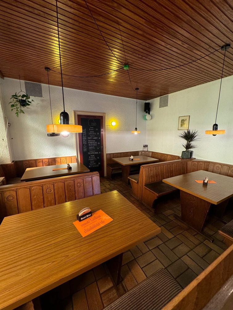 La cervecería desde el interior, con mesas y bancos rústicos.