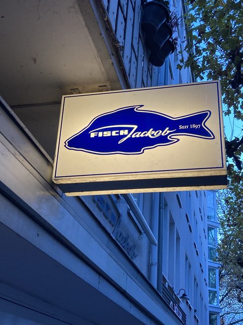 Insegna esterna con grafica a forma di pesce della pescheria "Fisch Jackob".
