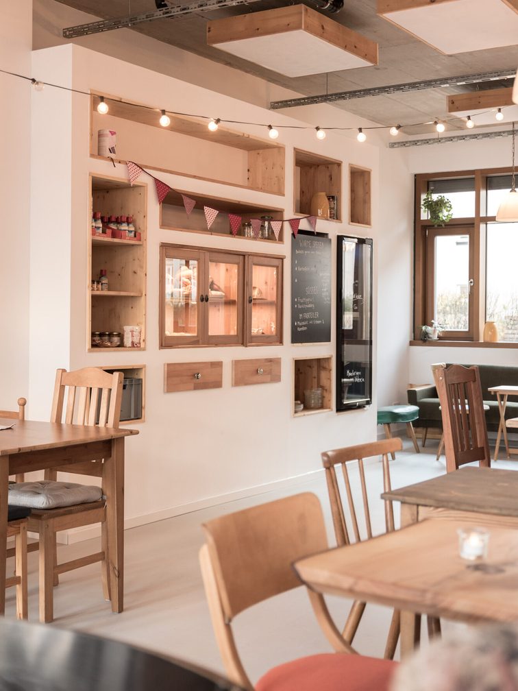 L'interno del caffè Krumm und Schepp con arredi rustici e ghirlanda di luci