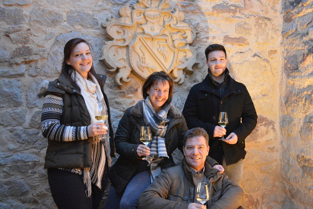 The Roos family in front of the family coat of arms in the courtyard.