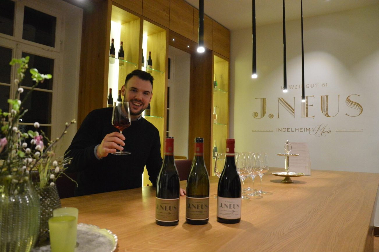 Le vigneron Lewis Schmitt lève un verre de vin rouge.