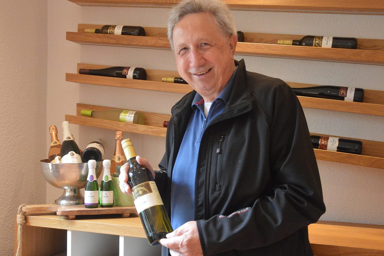 Wolfgang Thomas con una bottiglia di vino in mano