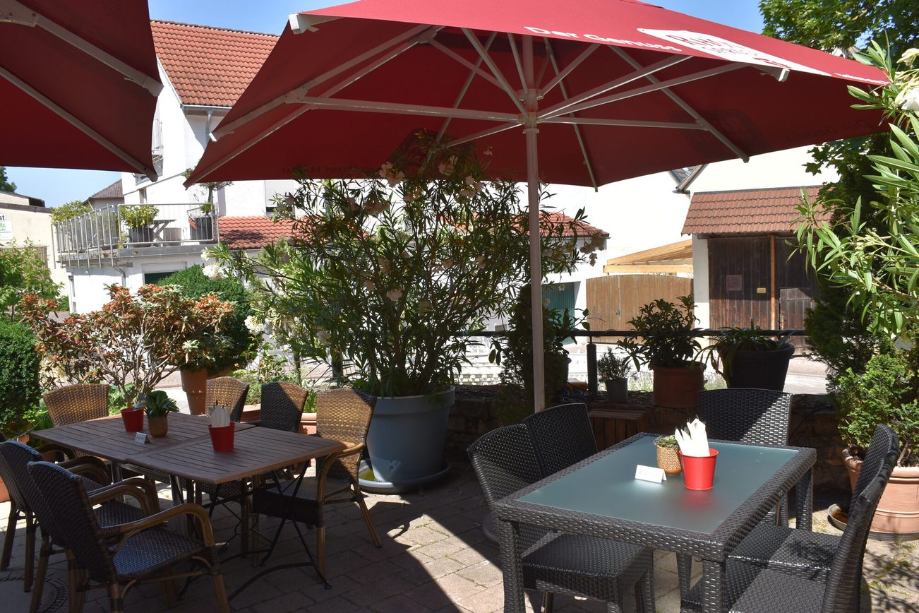 Espace extérieur devant les "Zornheimer Weinstuben" avec parasols et garniture
