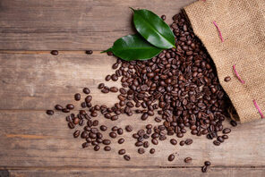 Kaffeesack mit Kaffeebohnen auf Holzboden © AdobeStock Stockwerk Fotodesign