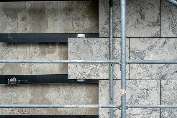 Façade de l'hôtel de ville avec échafaudage : à gauche, les panneaux extérieurs ont été enlevés, à droite, ils sont encore en place.