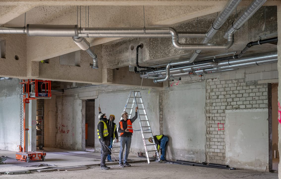 Vier Bauarbeiter im Innenraum der Rathaus-Baustelle