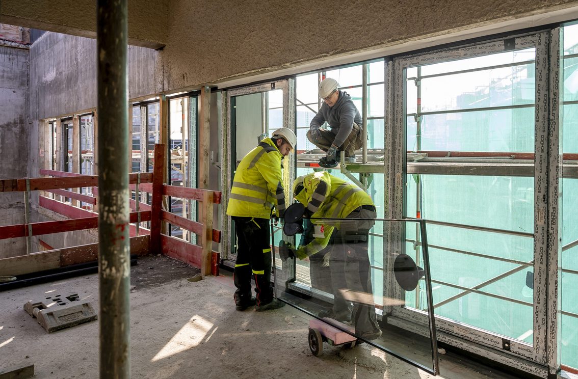 Bauarbeiter arbeiten an Fenstern.