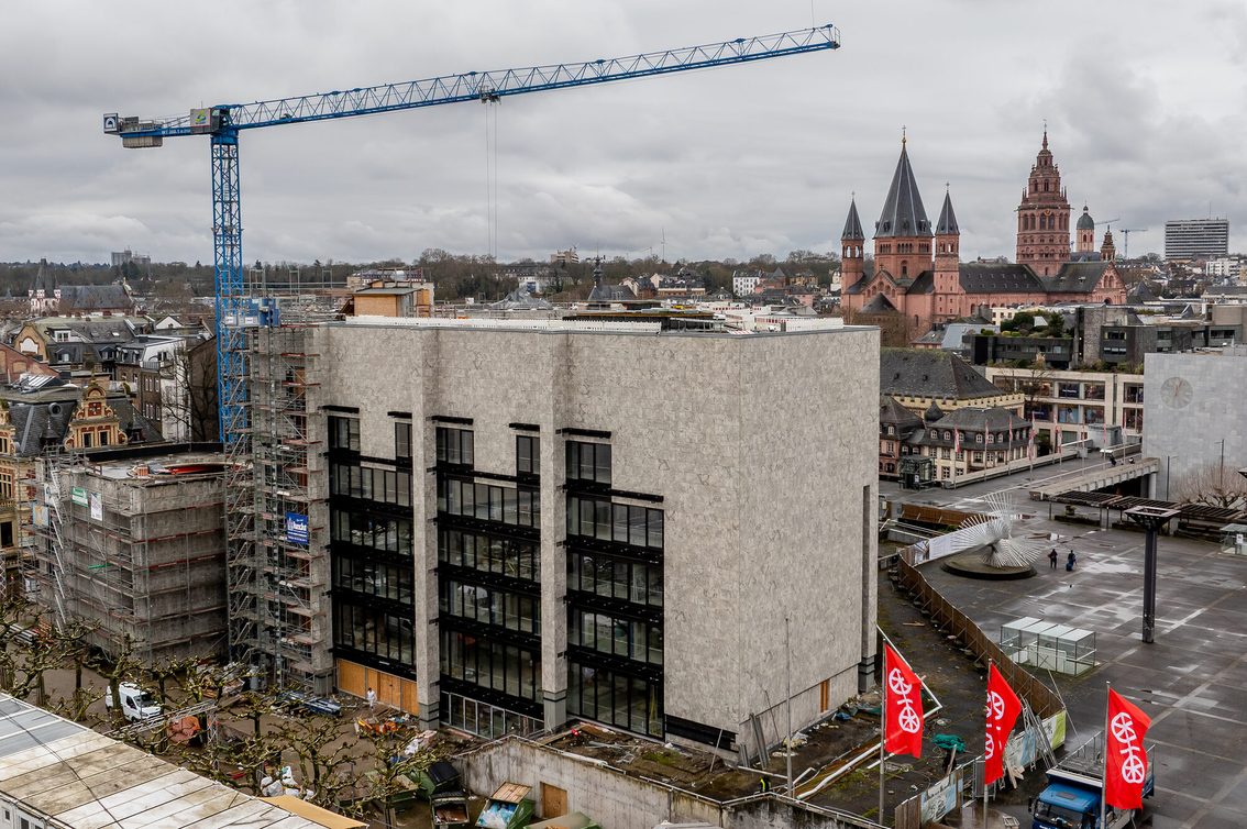Une grue se trouve devant le bâtiment de la mairie, avec la cathédrale de Mayence en arrière-plan.