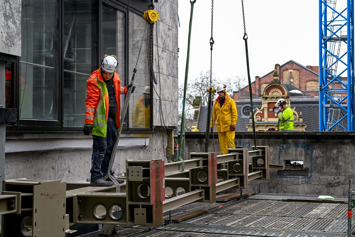 Les ouvriers du chantier de l'hôtel de ville posent une pièce d'acier