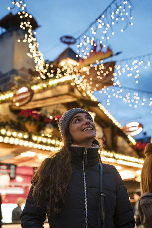 Eine Frau freut sich über die Beleuchtung auf dem Weihnachtsmarkt