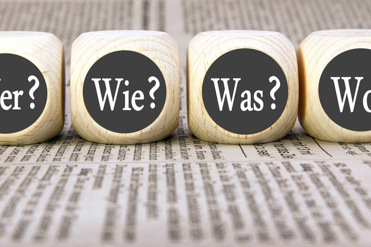 Vier Würfel mit der Aufschrift: Wer? Wie? Was? Wo?