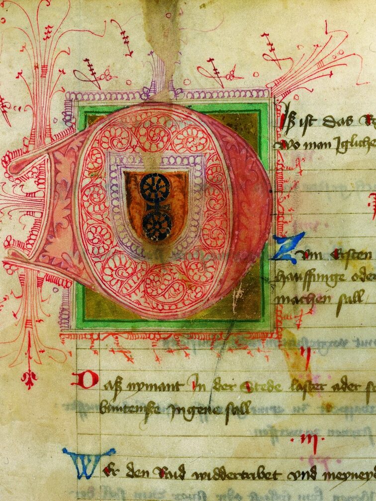 Ausschnitt aus dem Mainzer Friedebuch, zeigt rote Initiale mit Mainzer Rad