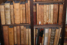 Holzregal mit in hellem Leder eingebundenen alten Kirchenbüchern