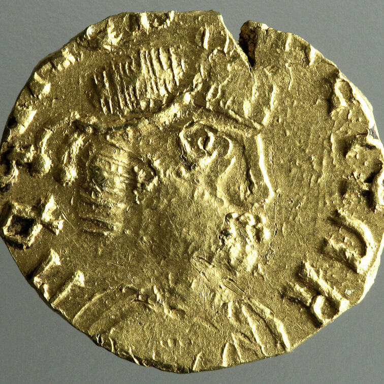 Alte goldene Münze, in der Mitte ein Brustbild.