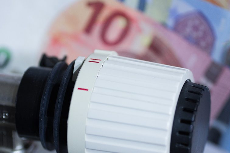 Termostato di riscaldamento con banconote sullo sfondo