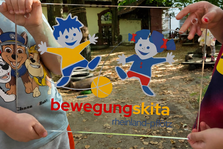 Auszeichnungsplakette "bewegungskita rheinland-pfalz", gehalten von Kinderhänden
