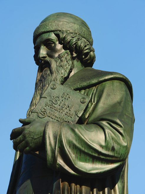 Estatua de Gutenberg frente a un cielo azul