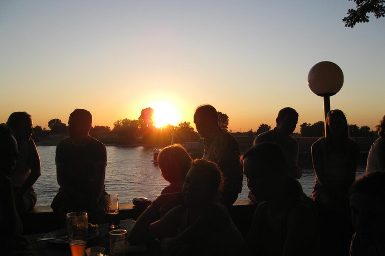 Menschen im Biergarten am Flußufer