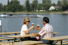 Zwei Gäste genießen ein Bier im Biergarten am Rheinufer