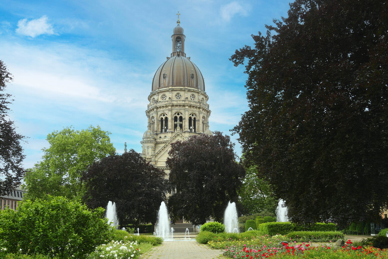 Christ Church in primavera, incorniciata da alberi, in primo piano la fontana con i gorgogliatori