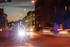 Fahrradfahrer mit Licht und Helm auf einem Radweg in der Dämmerung