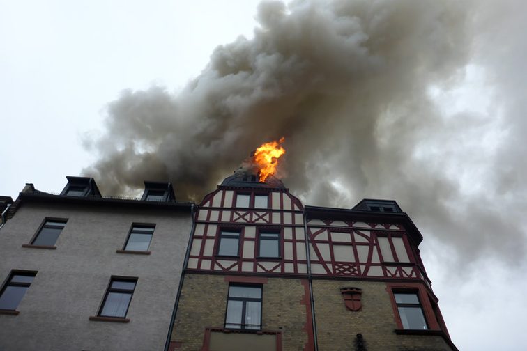 Flammen dringen aus dem Dachstuhl aus.