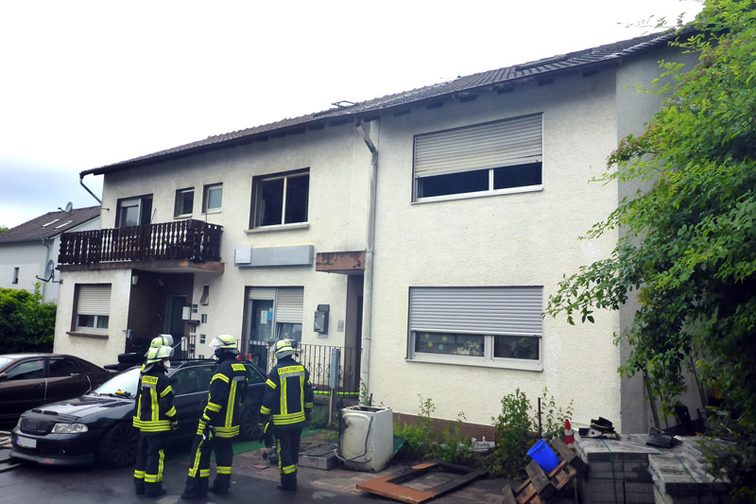 Einsatzkräfte vor dem Brandobjekt.