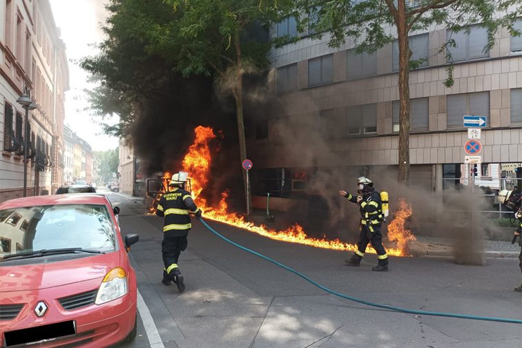 I servizi di emergenza davanti alla spazzatrice stradale in fiamme.