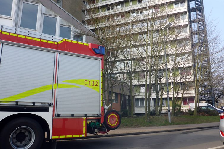 Camion de pompiers avec la façade de l'immeuble en arrière-plan.