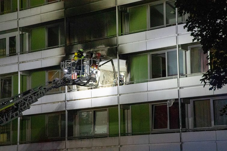 Strażacy używający drabiny obrotowej do gaszenia pożaru.