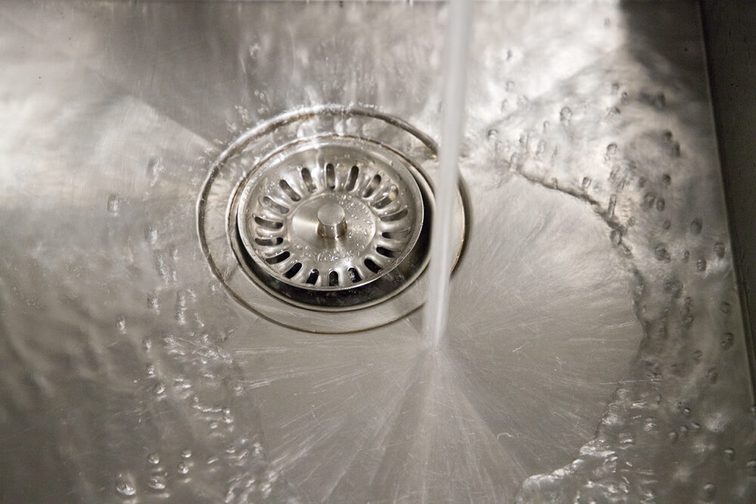 L'immagine mostra un lavandino in cui scorre l'acqua.