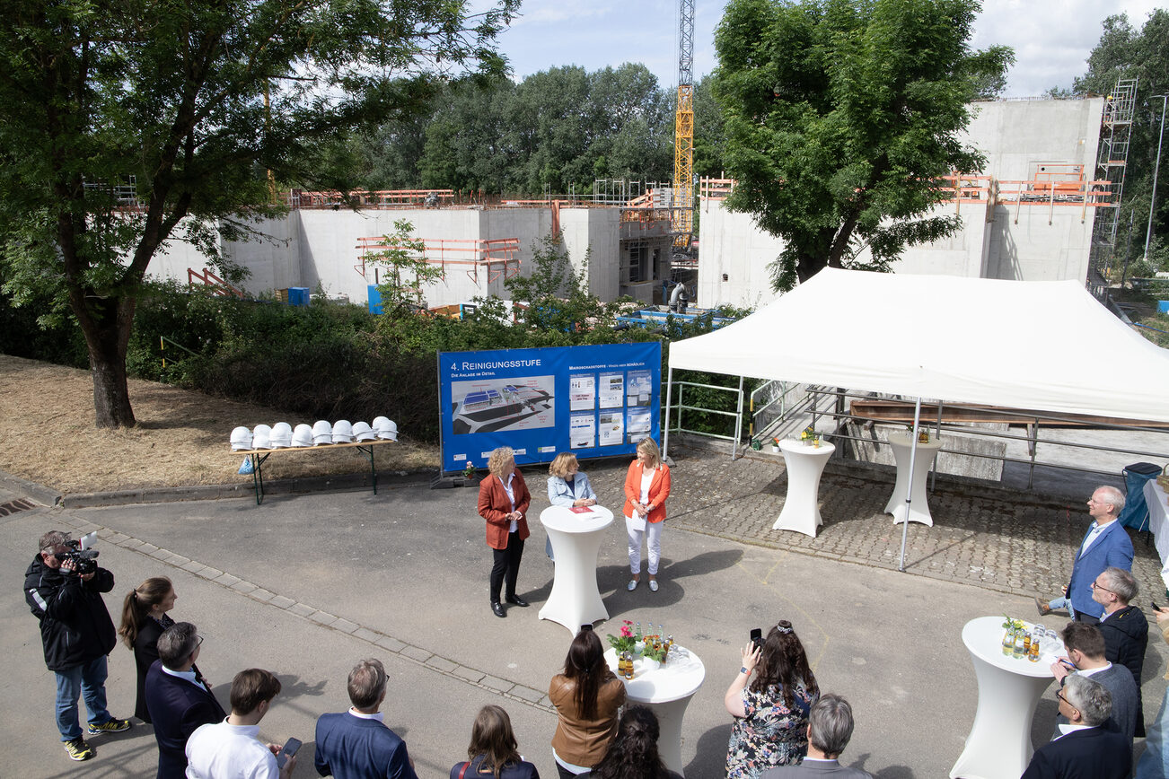 Blick von oben auf die Redner vor Gästen und Presse