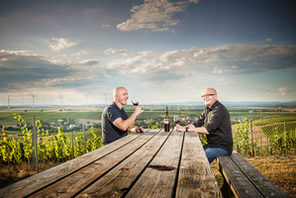 Zwei Männer an einem Tisch in den Weinbergen © Weingut Ernst Bretz