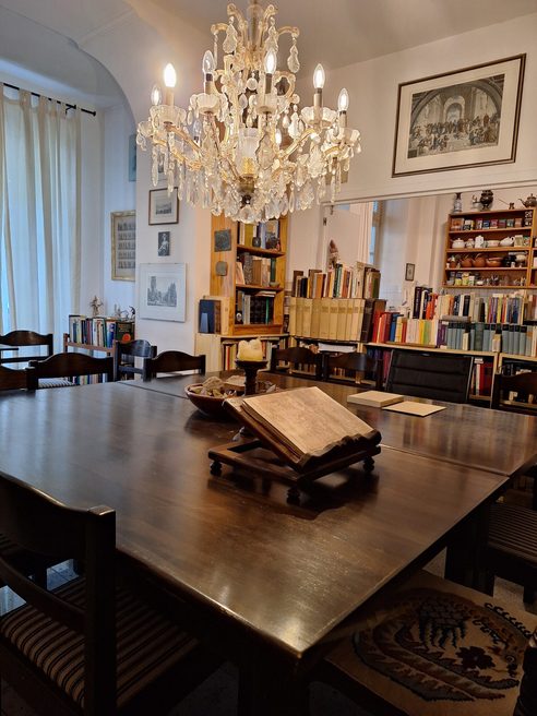 Dünya Kültürü Akademisi’ndeki kitap rafları, avizeler ve büyük ahşap masa